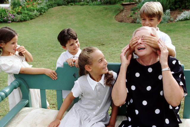 Grandmother and children playing a guessing game --- Image by © Norbert Schaefer/Corbis