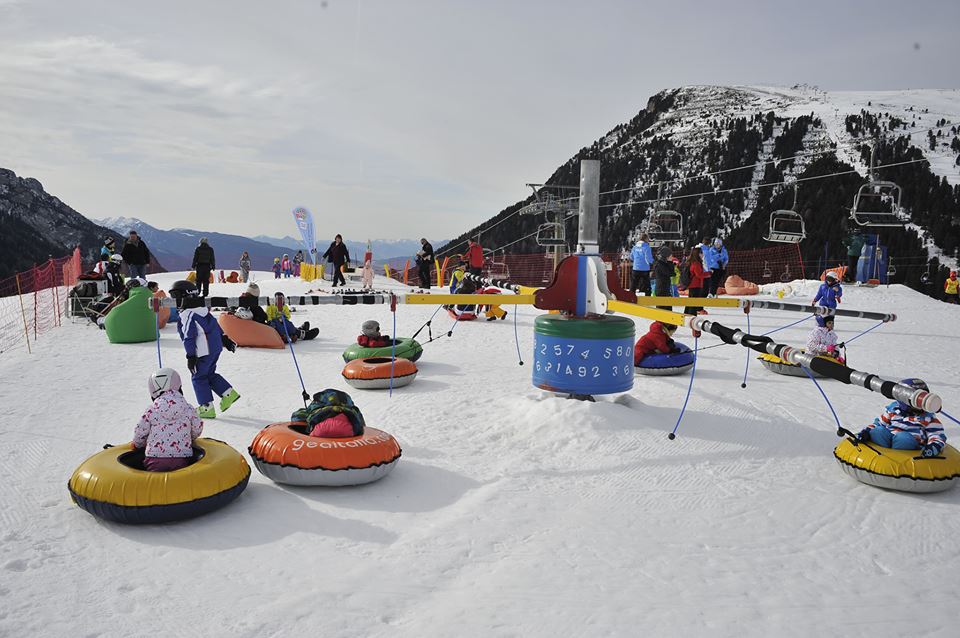 bambini su giostra con gommoni per neve