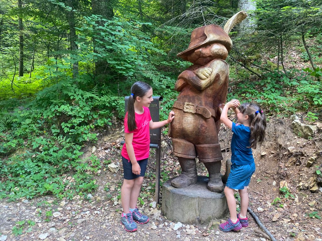 bambine con scultura in legno del gatto con gli stivali