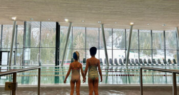 Le ampie vetrate assicurano luce naturale e una vista spettacolare sulle Dolomiti. Siamo alla piscina Dòlaondes di Canazei