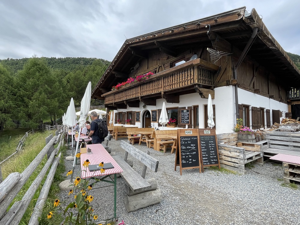 esterno di una malga con tavoli e panche