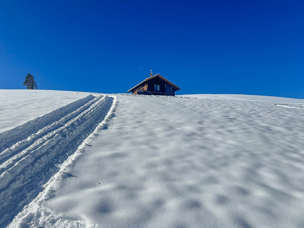 distesa di neve e baita in legno