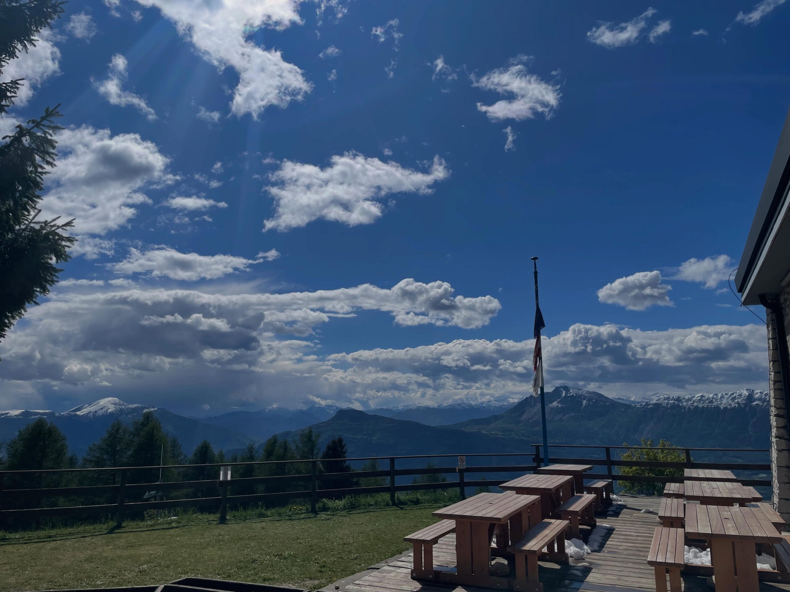 La vista sui prati del Finonchio, sulla strada per il Rifugio Filzi, spazia in lontananza verso le montagne